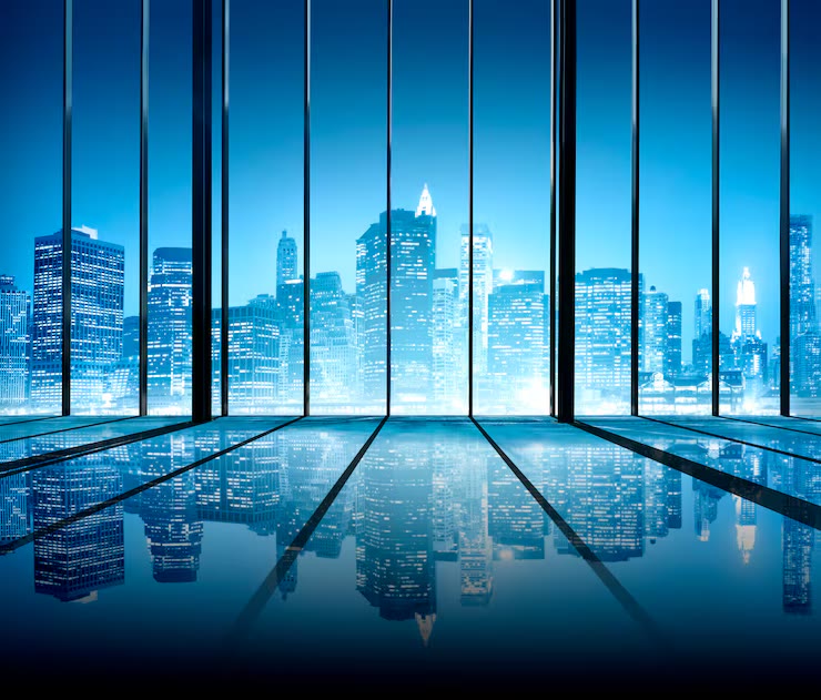 Night city skyline seen through floor-to-ceiling windows of a modern interior